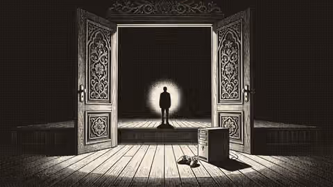 Silhouetted figure on a stage by open doors next to a desktop PC and controller.